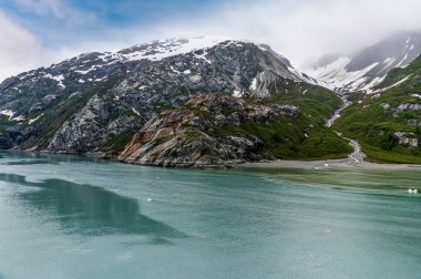 A view of moraine deposits at the waters edge in Glacier Bay beside the Reid Glacier, Alaska in summertime
