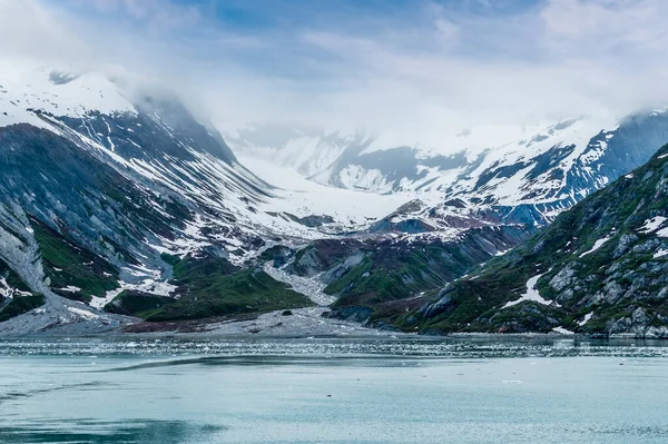 A view of snow filled valleys and moraine on the sides of Glacier Bay, Alaska in summertime