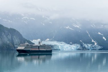 A view of a cruise ship sailing past the Margerie Glacier in Glacier Bay, Alaska in summertime