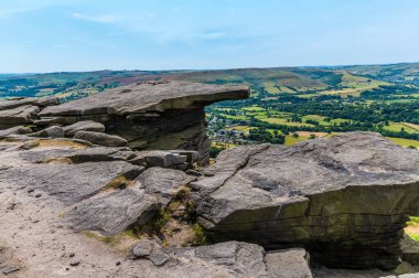 A view of overhanging rock slabs on the top of Bamford Edge, UK in summertime