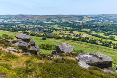 A view down towards the Bamford past the rocky outcrops of Bamford Edge, UK in summertime