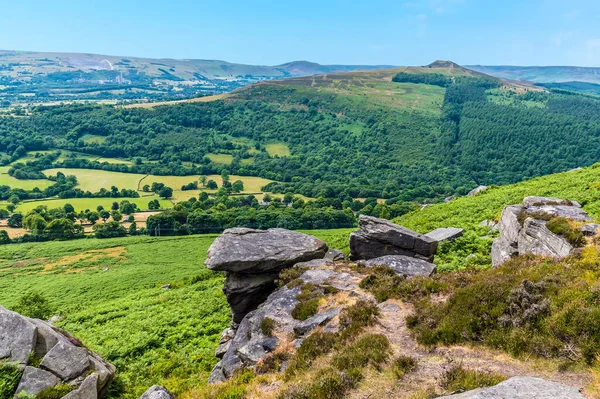 A view down towards the Hope Valley past the rocky outcrops of Bamford Edge, UK in summertime