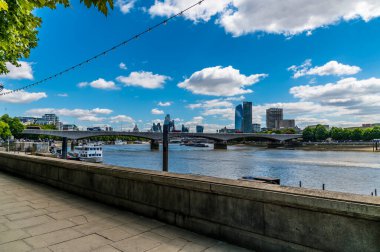 A view from the pavement of the Embankment along the River Thames towards Waterloo bridge in London, UK in summertime