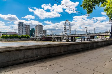 A view from the pavement of the Embankment along the River Thames towards Westminster in London, UK in summertime