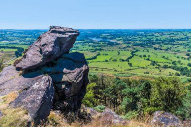 A view past boulders on the summit of the Roaches escarpment, Staffordshire, UK in summertime