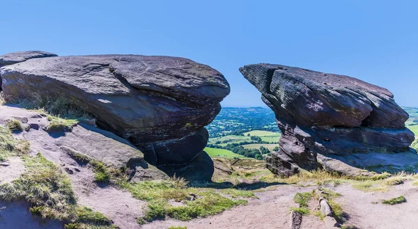 A view of the path passing between rock at the northern end of the Roaches escarpment, Staffordshire, UK in summertime