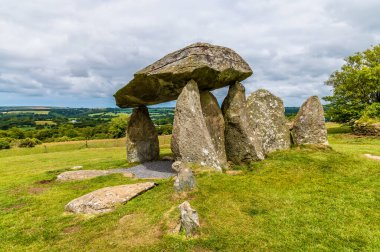 Galler 'in Pembrokeshire kentindeki Preseli tepelerindeki Pentre Ifan' daki eski bir mezar odasında dengeli bir kaya çatısının arka ve yan görüntüsü.