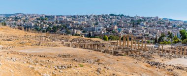 Yazın Ürdün 'ün Jerash kentindeki Gerasa antik Roma yerleşim yerindeki sütunlu bir caddenin karşısındaki panorama manzarası