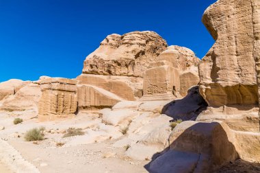 Ürdün 'ün eski Petra şehrine giden yolun yanındaki eski kaya yapılarının görüntüsü.