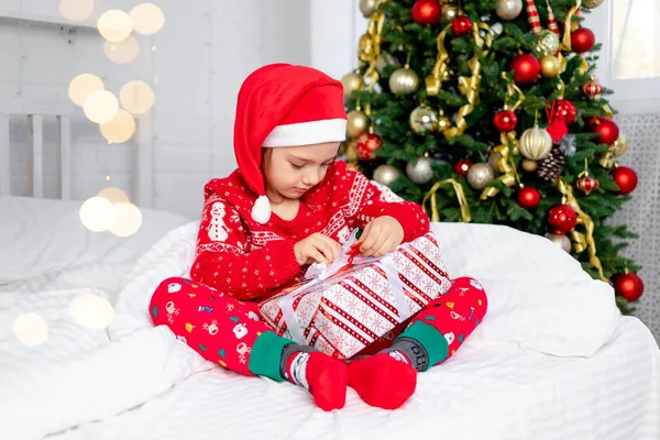 Child Girl Unpacks Gifts Christmas Tree Red Sweater Santa Claus — Stock Photo, Image