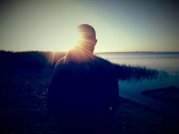 Gölün üzerinde gün batımında siluet.