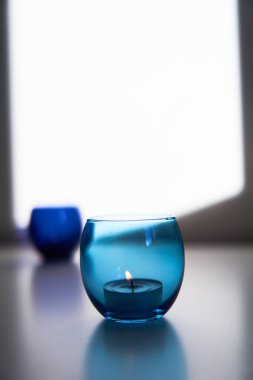 Koyu mavi ve açık mavi mum tutacaklarında yanan mumlar. Dekoratif cam mum kavanozları. Metin uzayı.