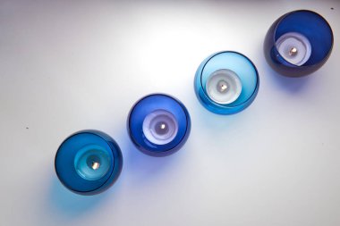 Koyu mavi ve açık mavi mum tutacaklarında yanan mumlar. Dekoratif cam mum kavanozları. Metin uzayı.