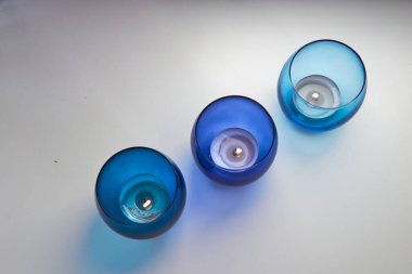 Koyu mavi ve açık mavi mum tutacaklarında yanan mumlar. Dekoratif cam mum kavanozları. Metin uzayı.