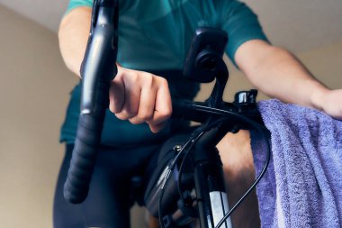 Adam evde akıllı bir antrenörle bisiklete biniyor. Evdeyken formda ve aktif kal. Kışın kapalı alanda bisiklet sürmek.