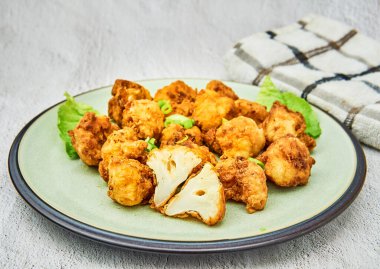 Beyaz arka planda vejetaryen karnabahar bufalo kanatları. Lezzetli vejetaryen yemekleri. Kızarmış karnabahar ısırıkları.