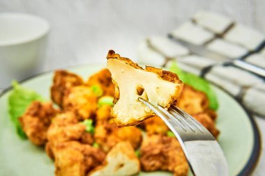 Çatal üzerinde vejetaryen bufalo kanadı. Lezzetli vejetaryen yemekleri yakın plan. Kızarmış karnabahar ısırıkları.