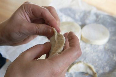 Elle hamur köftesi yapmak. Erkeklerin ellerinin yakın çekimi, vegan gyoza.