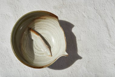 Kırık porselen bir kase ve beyaz bir arka plan. Kırık erişte kasesi