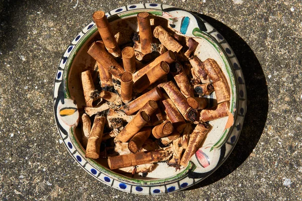 Sok Cigaretta Csikk Egy Vintage Hamutartóban Egy Kőasztalon — Stock Fotó