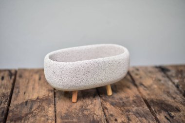 Ahşap masada beyaz saksılar var..