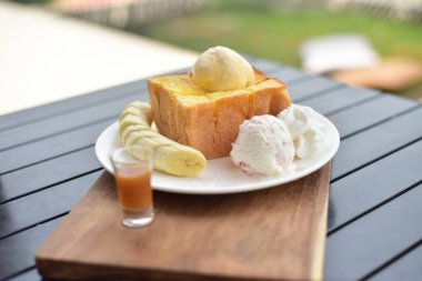 Kahve dükkanında beyaz tabakta muzlu tost..