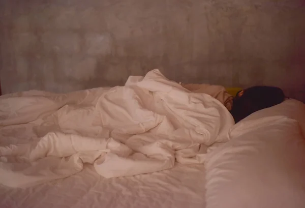 白いベッドで寝ている女性をぼかす ストック画像