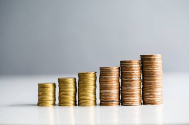 Para biriktirme kavramında gri arka planda birikmiş paralar.