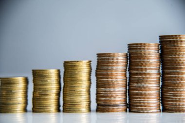 Coins stacking on gray background in saving money concept.