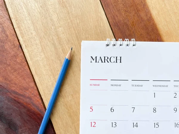 Calendar March with pencil on wood texture.inPlanning concept.