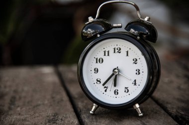 Bulanık arkaplanda siyah vintage saat.