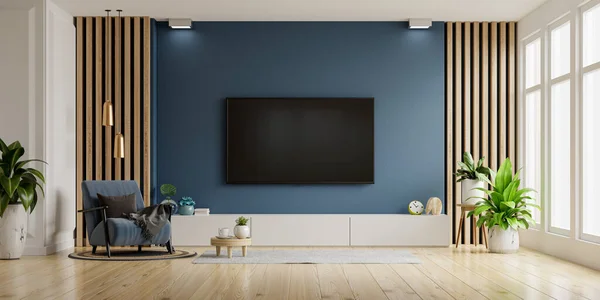 TV and Cabinet in modern living room with blue armchair on dark blue concrete wall background.3d rendering
