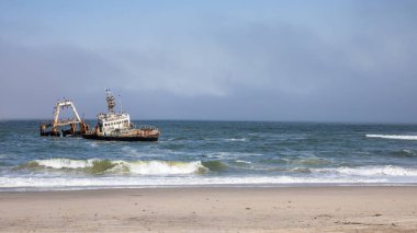 Namibya, Afrika, Swakopmund yakınlarındaki Skeleton Coast içinde sıkışmış Zeila geminin terkedilmiş gemi batığı, enkaz üzerinde oturan birçok karabatak ile.