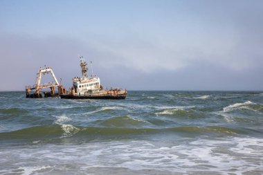 Namibya, Afrika, Swakopmund yakınlarındaki Skeleton Coast içinde sıkışmış Zeila geminin terkedilmiş gemi batığı, enkaz üzerinde oturan birçok karabatak ile.