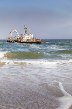 Namibya, Afrika, Swakopmund yakınlarındaki Skeleton Coast içinde sıkışmış Zeila geminin terkedilmiş gemi batığı, enkaz üzerinde oturan birçok karabatak ile.
