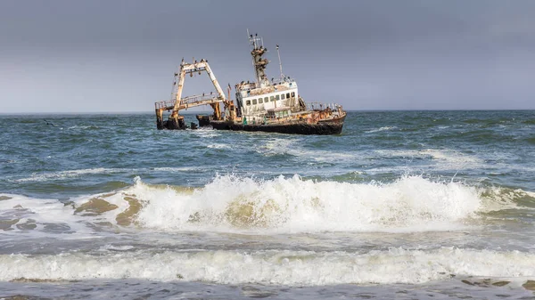 Namibya, Afrika, Swakopmund yakınlarındaki Skeleton Coast içinde sıkışmış Zeila geminin terkedilmiş gemi batığı, enkaz üzerinde oturan birçok karabatak ile.
