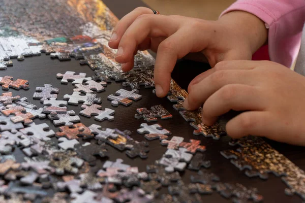 Een klein meisje die thuis legpuzzelt. Close up foto met selectieve focus. — Stockfoto