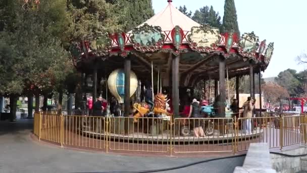 Baku - Azerbaijan, December 31, 2021: The colorful retro carousel with horses in Baku. Happy kids ride merry-go-round — Vídeo de Stock