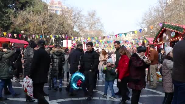 Gente feliz celebrando las fiestas navideñas. Día de Navidad en la calle central de Bakú - Azerbaiyán: 31 de diciembre de 2021 — Vídeos de Stock