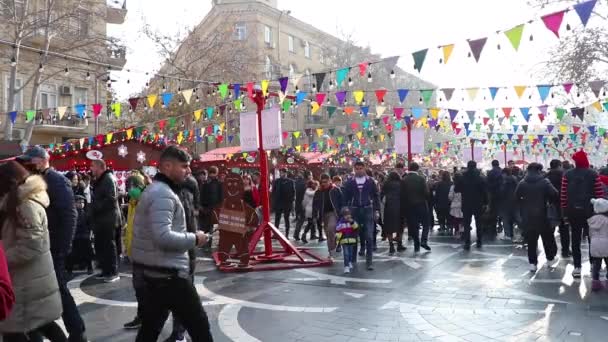 New Years Fair in the center square. Happy people at holiday. Christmas day in Baku, Azerbaijan - December 31, 2021. — Stockvideo
