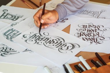 Tipografi Hattatçısı çizim çizimi yazarken imlâ edilen kalem fırçası mürekkep tablosu çizimlerine izin veriyor. İş yeri tasarım stüdyosu.