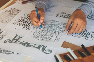 Tipografi Hattatçısı çizim çizimi yazarken imlâ edilen kalem fırçası mürekkep tablosu çizimlerine izin veriyor. İş yeri tasarım stüdyosu.