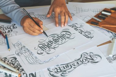 Tipografi Hattatçısı çizim çizimi yazarken imlâ edilen kalem fırçası mürekkep tablosu çizimlerine izin veriyor. İş yeri tasarım stüdyosu.