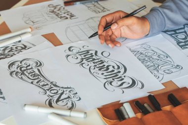 Tipografi Hattatçısı çizim çizimi yazarken imlâ edilen kalem fırçası mürekkep tablosu çizimlerine izin veriyor. İş yeri tasarım stüdyosu.