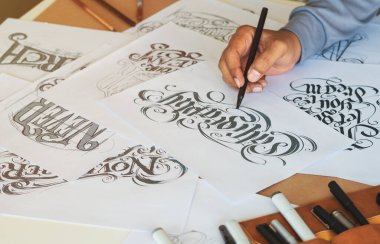 Tipografi Hattatçısı çizim çizimi yazarken imlâ edilen kalem fırçası mürekkep tablosu çizimlerine izin veriyor. İş yeri tasarım stüdyosu.