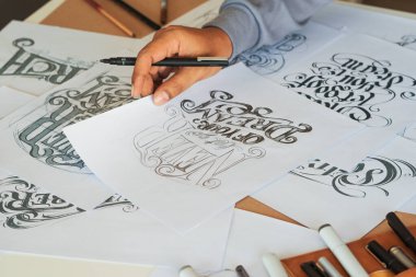 Tipografi Hattatçısı çizim çizimi yazarken imlâ edilen kalem fırçası mürekkep tablosu çizimlerine izin veriyor. İş yeri tasarım stüdyosu.