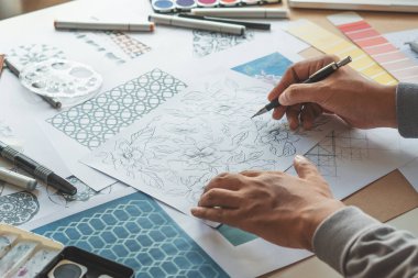 Designer designing drawing sketch pattern geometric flower seamless wallpaper fabric textile fashion industry. artistic design studio