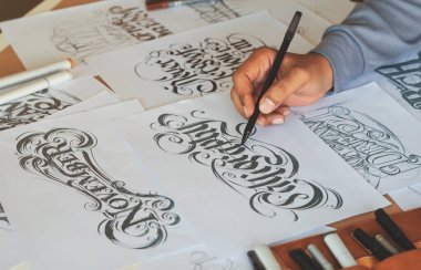 Tipografi Hattatçısı çizim çizimi yazarken imlâ edilen kalem fırçası mürekkep tablosu çizimlerine izin veriyor. İş yeri tasarım stüdyosu.