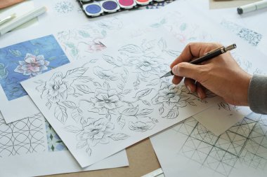 Designer designing drawing sketch pattern geometric flower seamless wallpaper fabric textile fashion industry. artistic design studio
