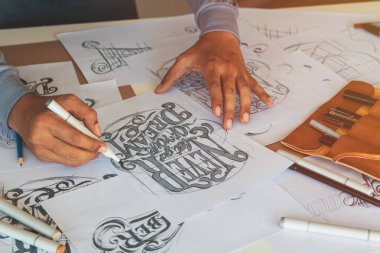 Tipografi Hattatçısı çizim çizimi yazarken imlâ edilen kalem fırçası mürekkep tablosu çizimlerine izin veriyor. İş yeri tasarım stüdyosu.